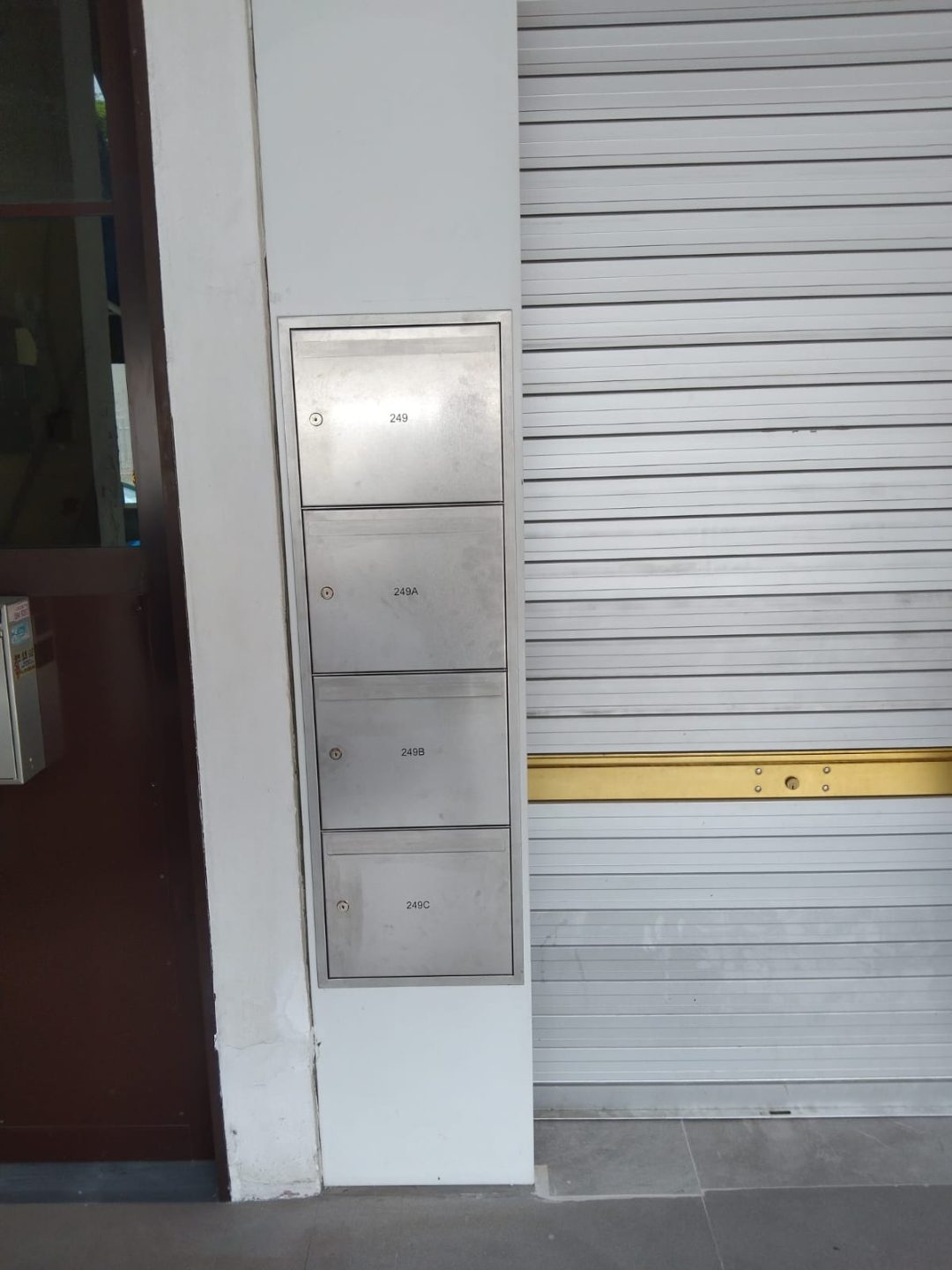 SS304 stainless steel mailbox installed against the wall beside the main entrance corridor at Outram Road